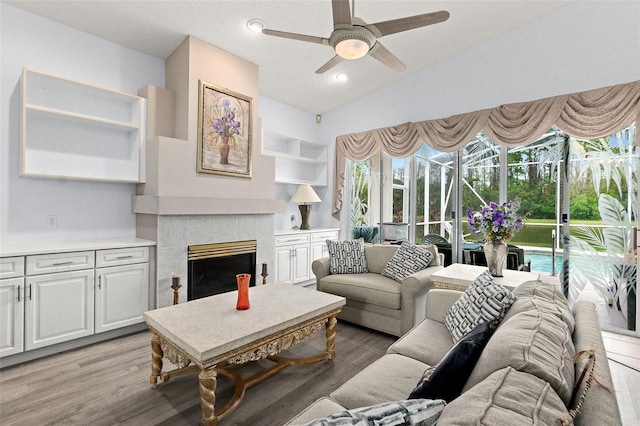 living area with a healthy amount of sunlight, light wood-style flooring, and a tile fireplace