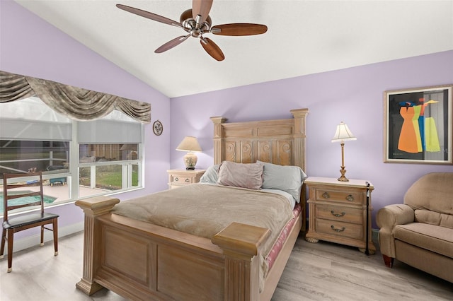 bedroom featuring a ceiling fan, lofted ceiling, and light wood-style floors