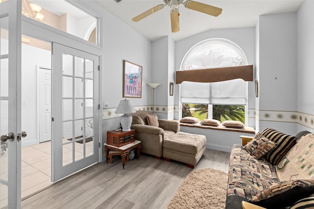 living area with french doors, a ceiling fan, light wood-type flooring, and lofted ceiling