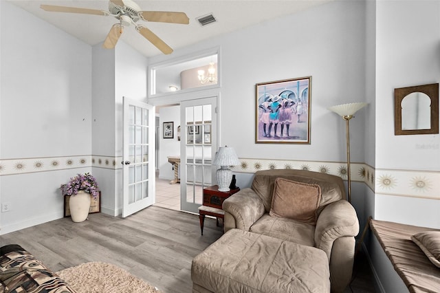 living room with wood finished floors, visible vents, french doors, and ceiling fan