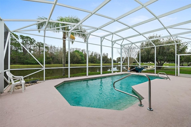 outdoor pool with glass enclosure, a patio area, and a water view