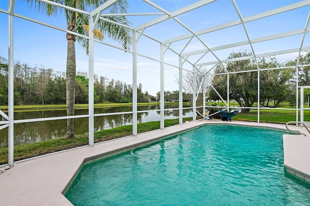 pool with glass enclosure, a patio area, and a water view