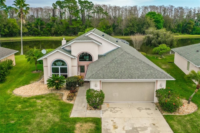 view of front of property featuring an attached garage, a water view, a front yard, stucco siding, and driveway