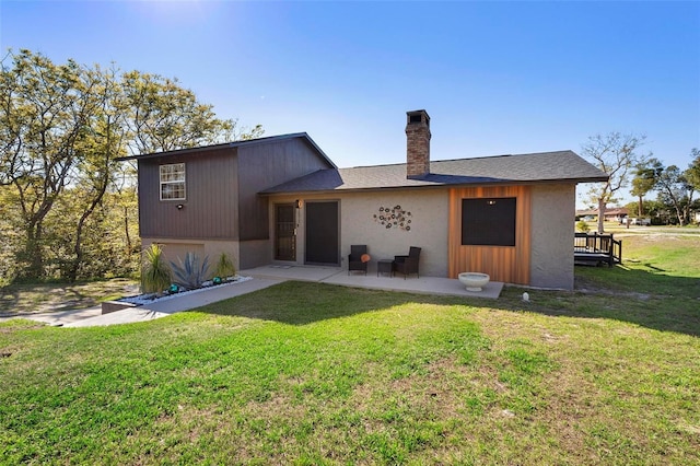 back of property featuring a patio, a lawn, and a chimney