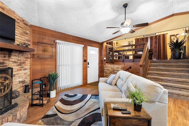 living area featuring ceiling fan, wood finished floors, and vaulted ceiling