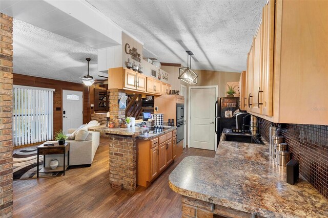 kitchen featuring a ceiling fan, a sink, a textured ceiling, open floor plan, and dark wood-style flooring