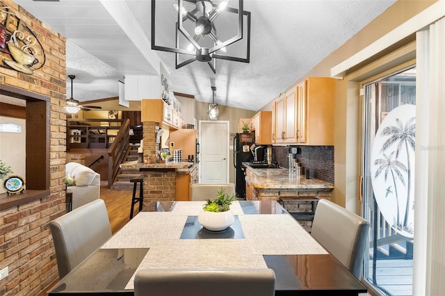 dining space featuring ceiling fan, stairs, lofted ceiling, wood finished floors, and a textured ceiling