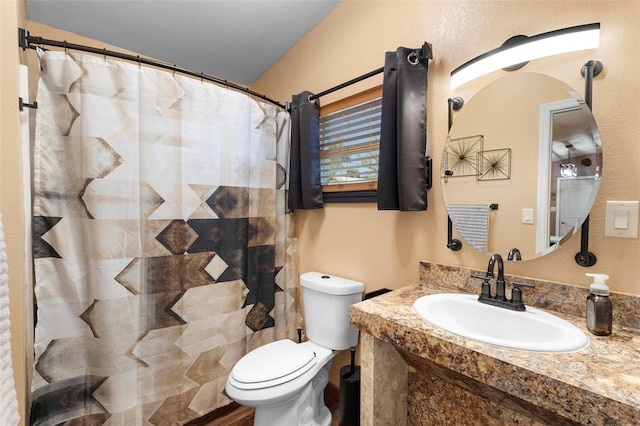 bathroom featuring a shower with shower curtain, toilet, and vanity