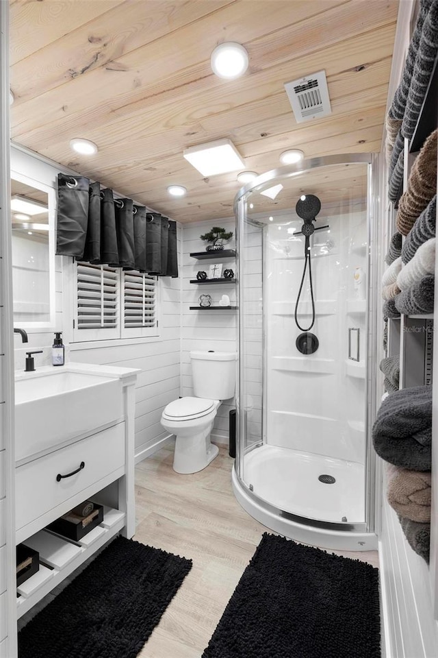 bathroom with visible vents, toilet, a stall shower, wood finished floors, and wooden ceiling