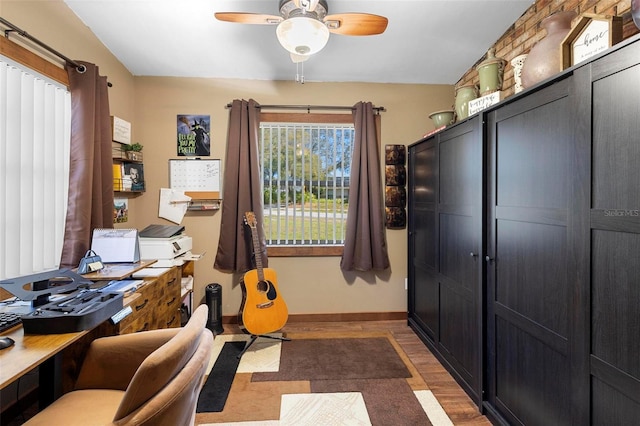 office space with a ceiling fan, wood finished floors, and baseboards