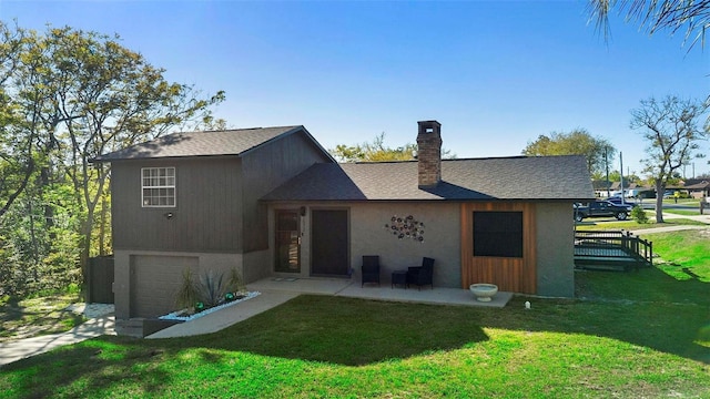 back of property with a shingled roof, concrete driveway, a lawn, a chimney, and a garage