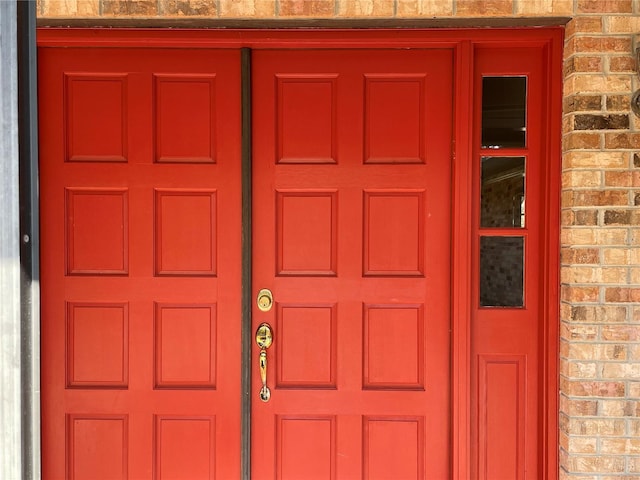 entrance to property featuring brick siding