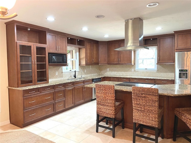 kitchen featuring open shelves, a breakfast bar, island range hood, black appliances, and a sink