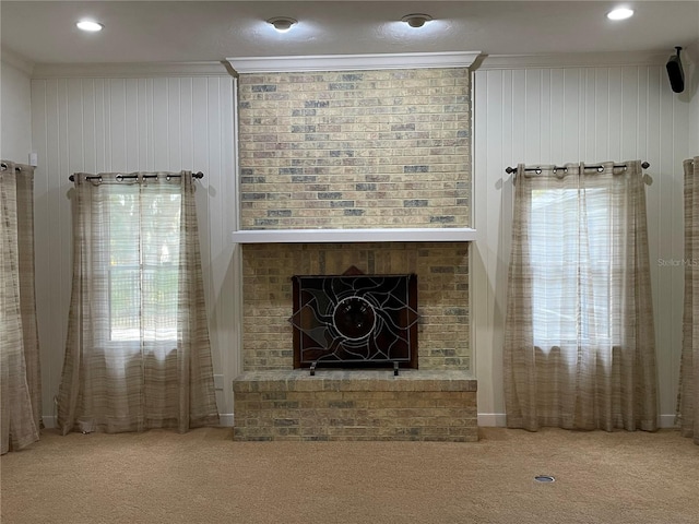 unfurnished living room with crown molding, a fireplace, and carpet floors