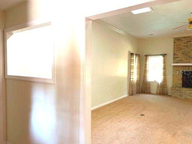 unfurnished living room featuring ceiling fan, baseboards, and carpet