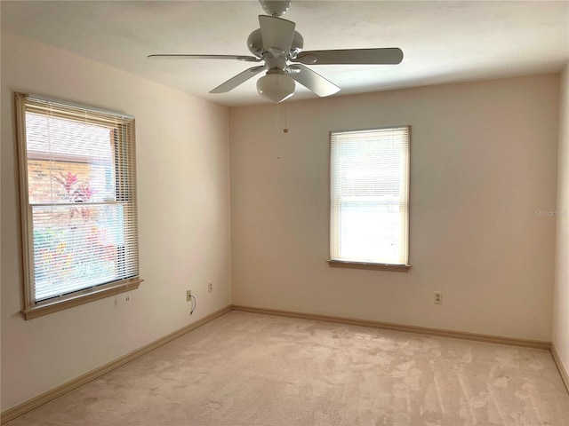 unfurnished room with plenty of natural light, baseboards, and light carpet