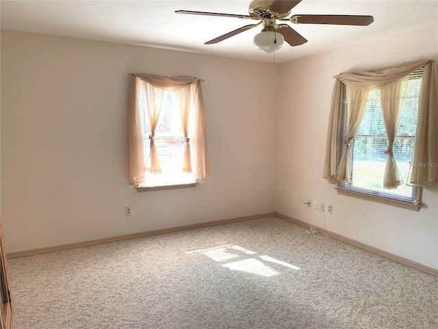 unfurnished room with baseboards, plenty of natural light, ceiling fan, and carpet flooring