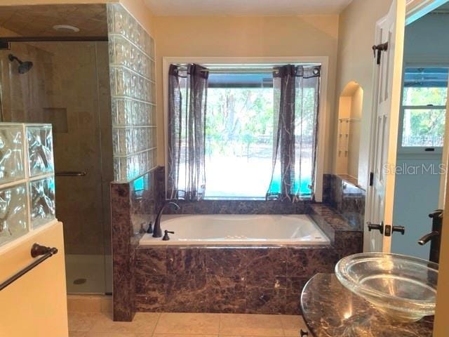 full bath featuring a wealth of natural light, a stall shower, and a sink