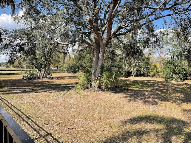 view of yard with a rural view and fence