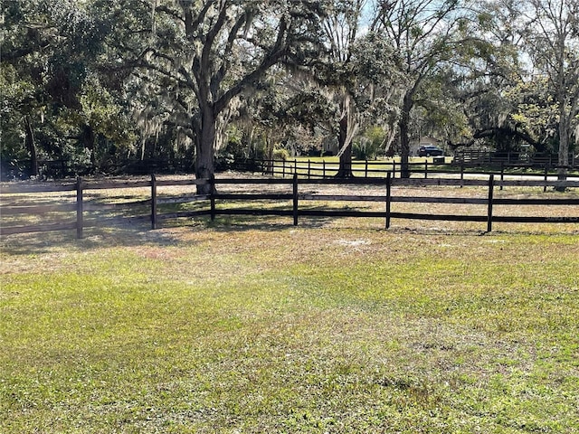 view of yard with a rural view and fence