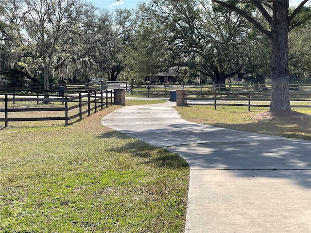 view of community featuring a yard and fence