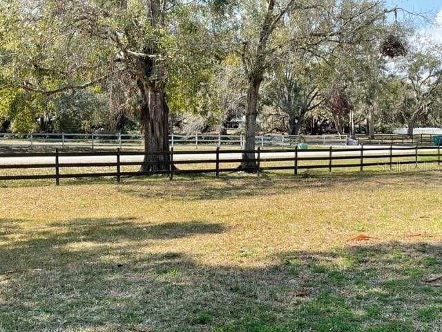 view of yard with a rural view and fence