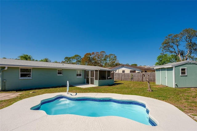 view of pool featuring an outbuilding, a fenced backyard, a yard, a sunroom, and a fenced in pool