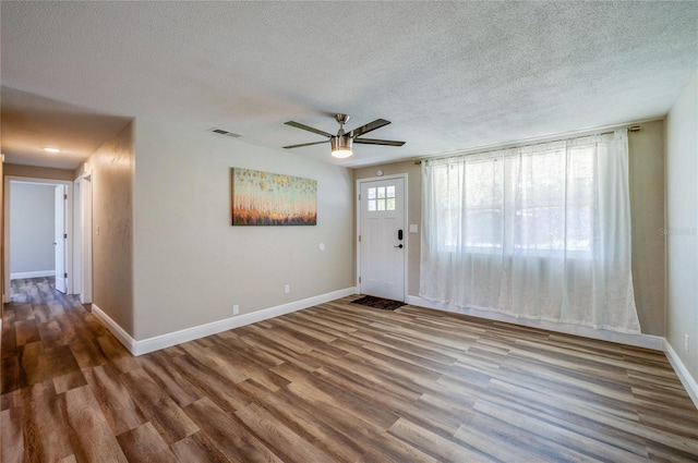 entrance foyer featuring visible vents, baseboards, wood finished floors, a textured ceiling, and a ceiling fan