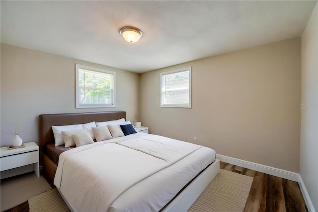 bedroom with baseboards and wood finished floors