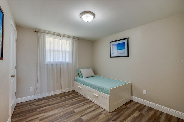 unfurnished bedroom featuring baseboards and wood finished floors