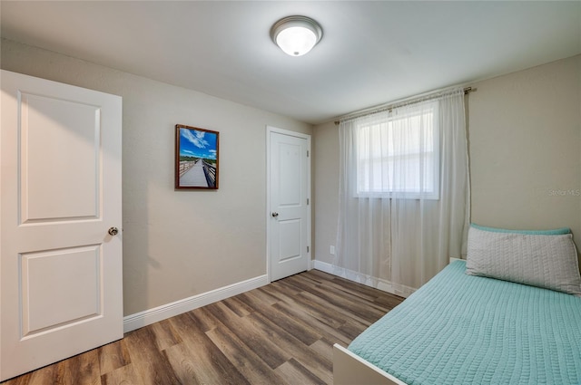 unfurnished bedroom with wood finished floors and baseboards