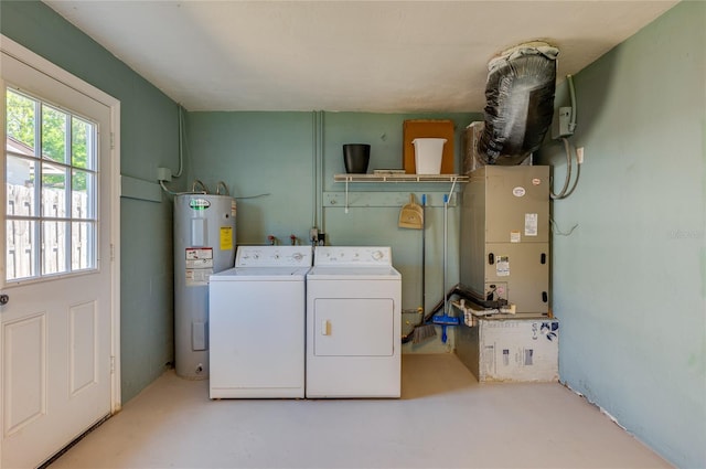 washroom with washing machine and clothes dryer, laundry area, heating unit, and electric water heater