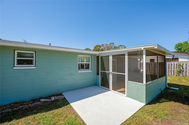 back of house featuring a yard, fence, and a sunroom