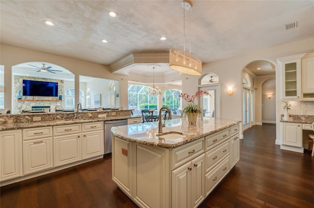 kitchen featuring a sink, visible vents, arched walkways, and dishwasher