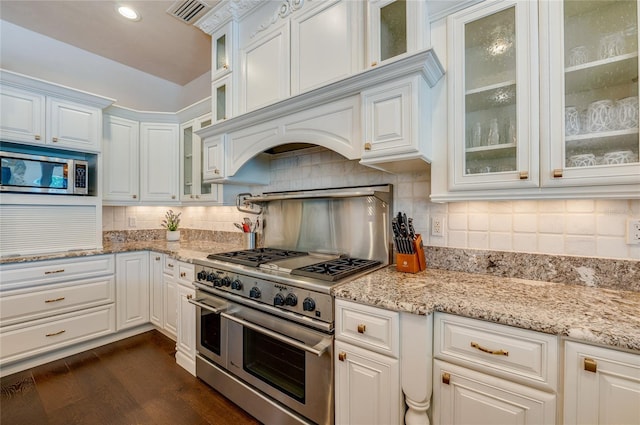 kitchen with dark wood finished floors, white cabinets, visible vents, and stainless steel appliances