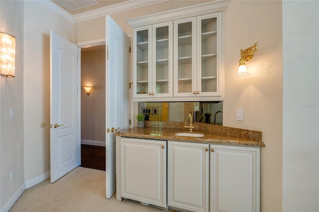 bar featuring visible vents, crown molding, baseboards, indoor wet bar, and a sink