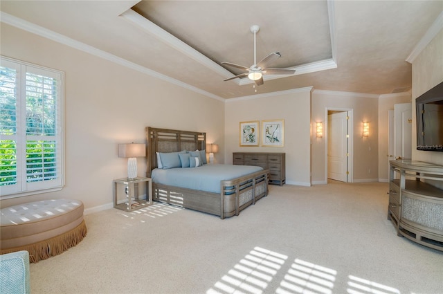 carpeted bedroom featuring baseboards, a ceiling fan, a tray ceiling, and ornamental molding