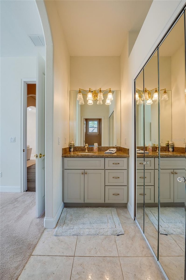 bathroom featuring tile patterned flooring, visible vents, vanity, and baseboards