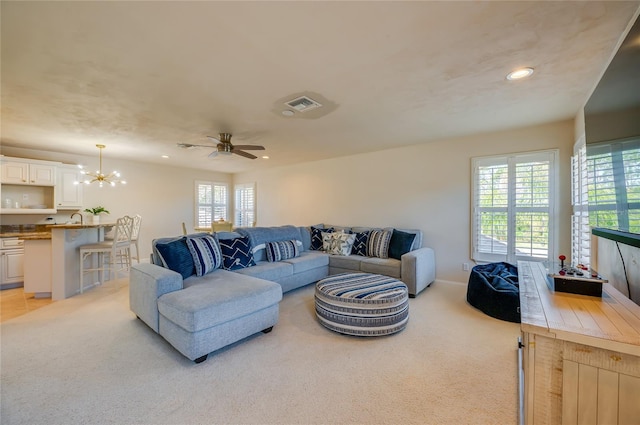 living area with recessed lighting, light colored carpet, ceiling fan with notable chandelier, and visible vents