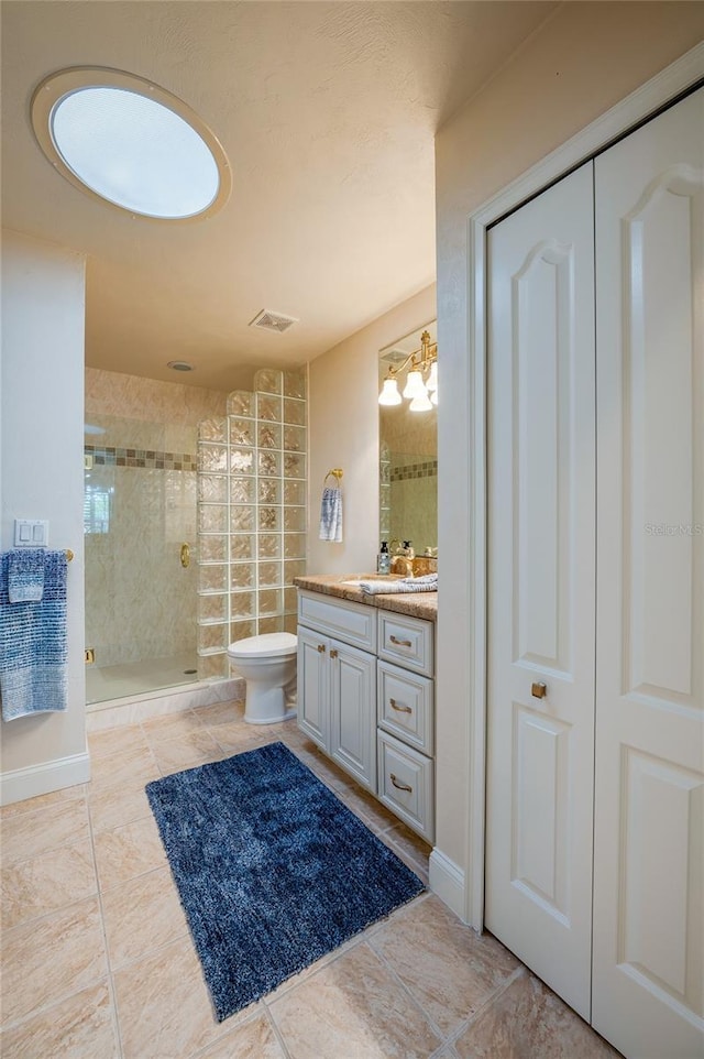 bathroom with visible vents, toilet, a stall shower, baseboards, and vanity