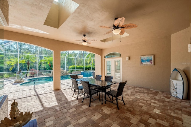 view of patio / terrace with glass enclosure, french doors, outdoor dining area, an outdoor pool, and a ceiling fan