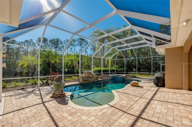 view of pool featuring a patio area, glass enclosure, and a pool with connected hot tub