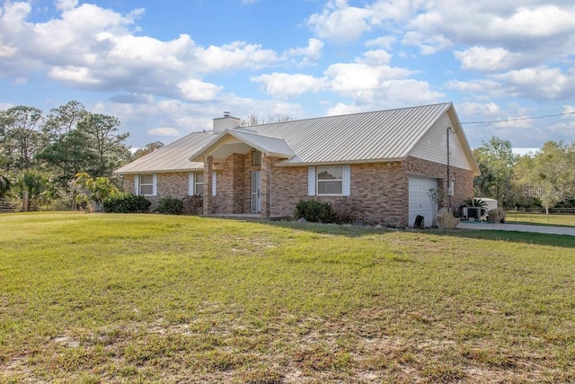 single story home featuring fence, an attached garage, a front lawn, brick siding, and metal roof