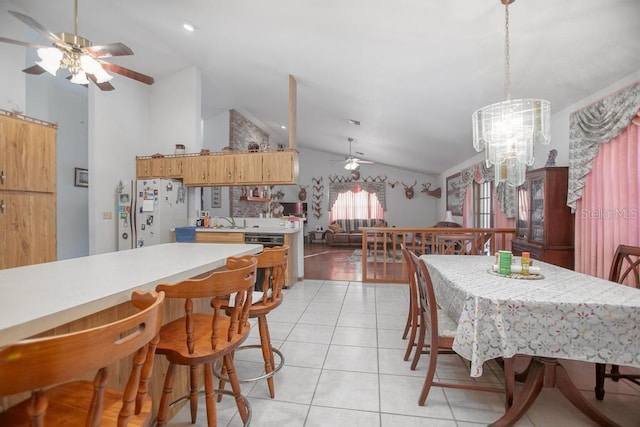 dining space featuring light tile patterned floors, lofted ceiling, and ceiling fan with notable chandelier