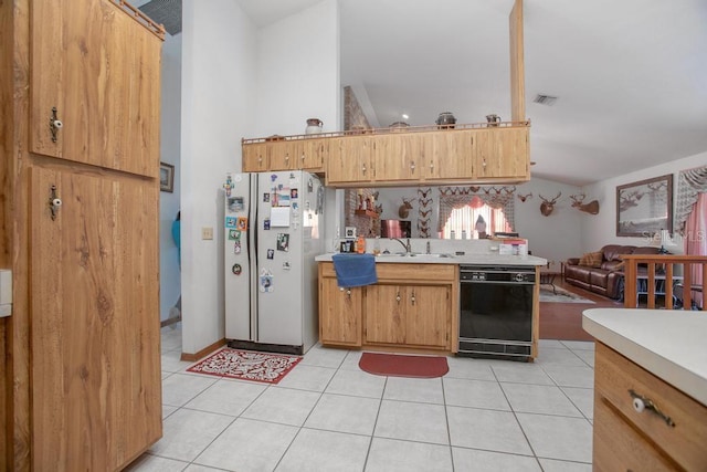 kitchen with open floor plan, light countertops, black dishwasher, light tile patterned floors, and freestanding refrigerator