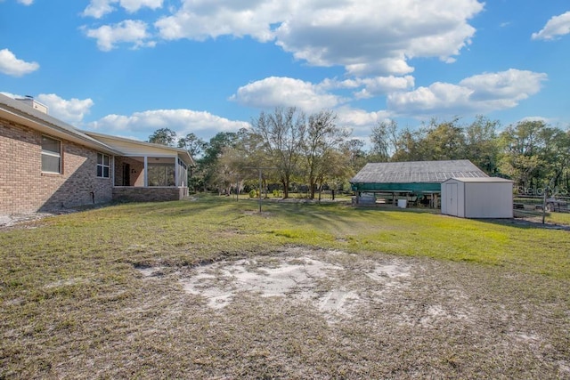 view of yard featuring an outbuilding, a sunroom, and a shed