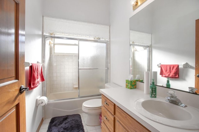 bathroom with tile patterned floors, combined bath / shower with glass door, toilet, and vanity