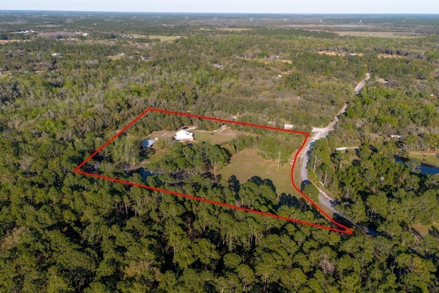 birds eye view of property featuring a forest view