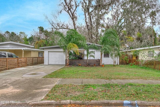 view of front of property with a front lawn, concrete driveway, fence, and a garage