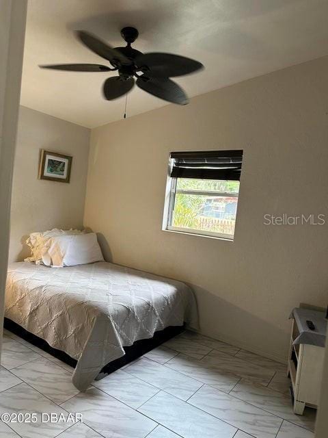 bedroom with lofted ceiling, marble finish floor, and ceiling fan